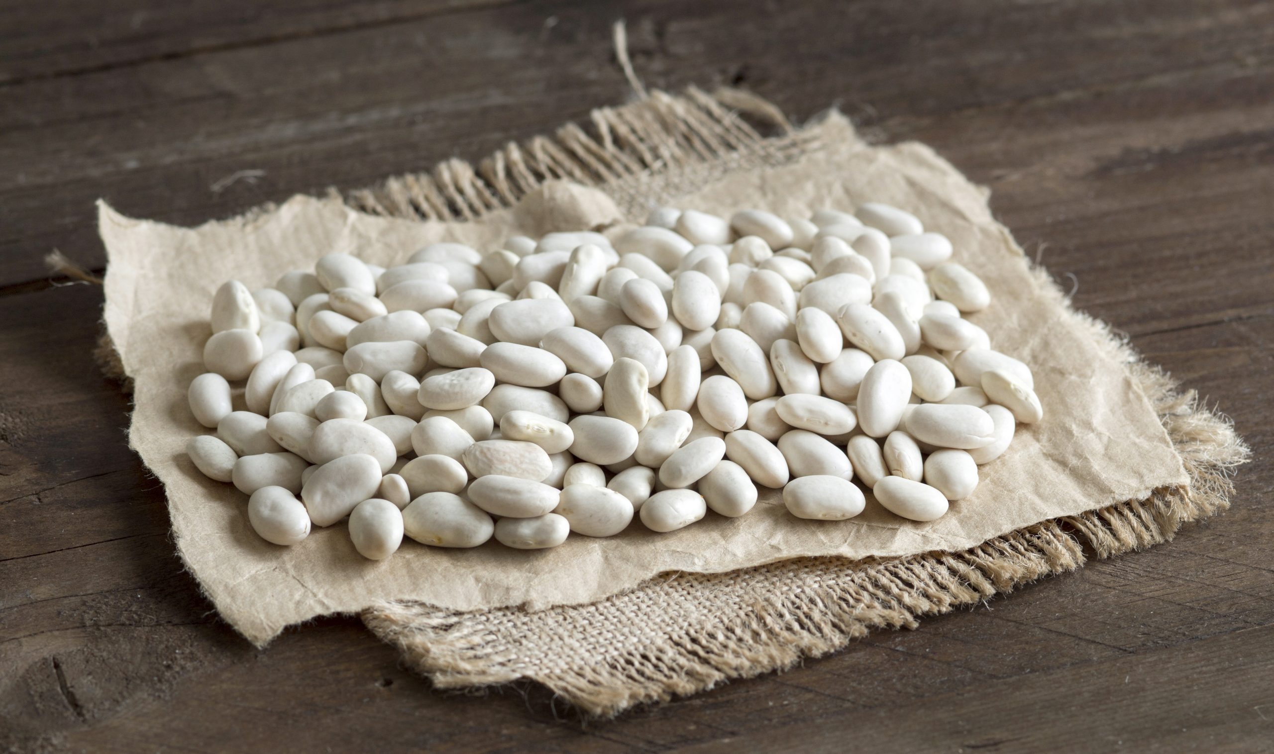 Pile of White beans on a wooden bacground
